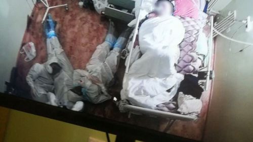 Se hace viral esta imagen de tres sanitarios en el suelo acompañando a una paciente de Covid-19